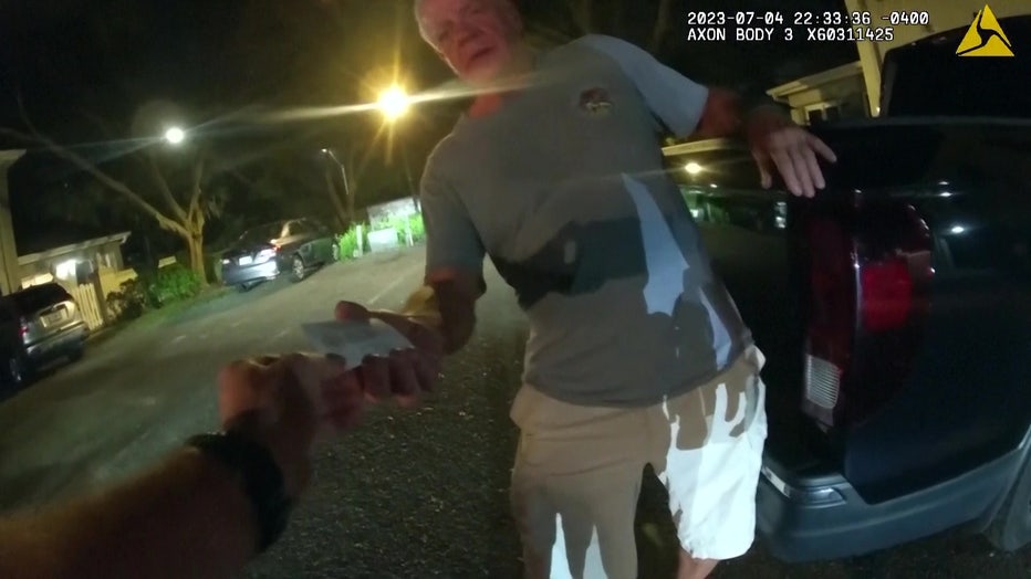 Bodycam video shows Joseph Ruddy handing an officer a business card while being arrested for DUI.