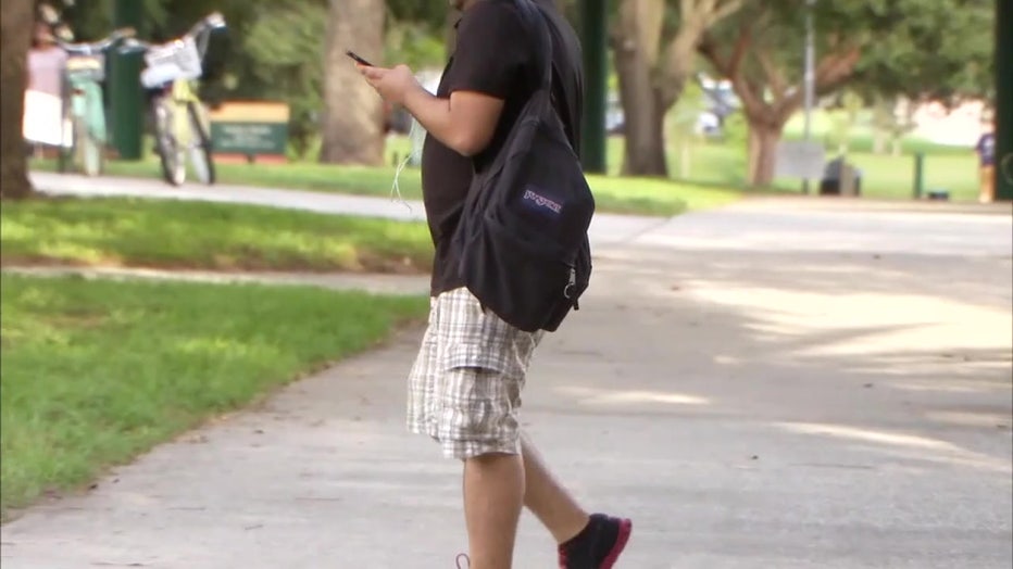 File: Student walking on school campus.