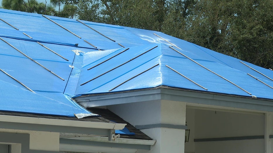 A blue tarp covers a roof damaged in Hurricane Ian. 