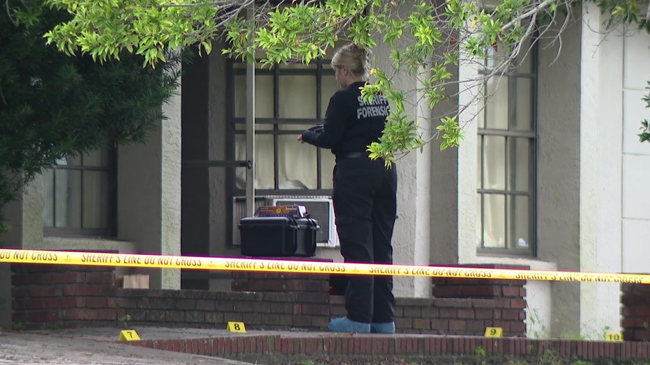 Crime scene tape and an investigator at the scene of a deadly home invasion in Spring Hill.