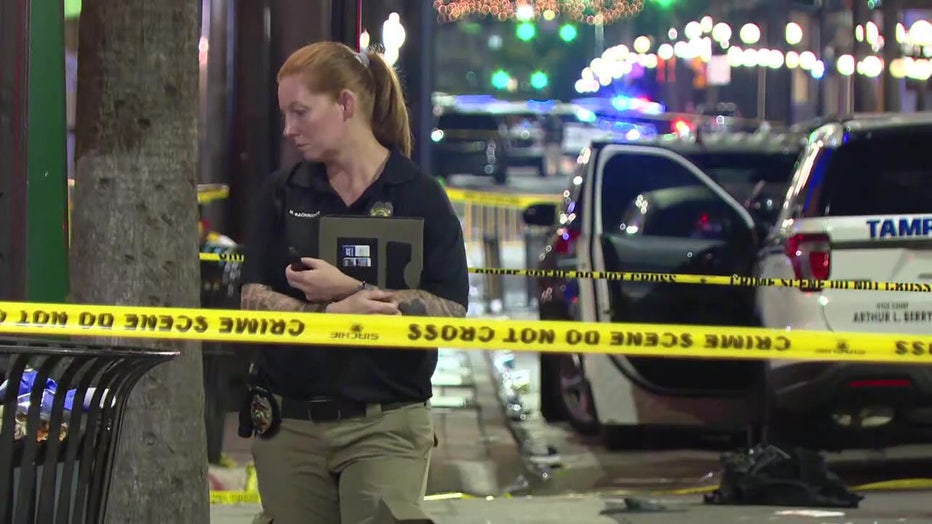 Law enforcement officer and crime scene tape at scene of deadly Ybor City shooting.