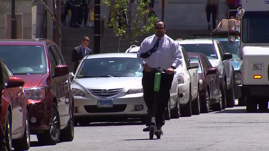 A man rides an e-scooter. 