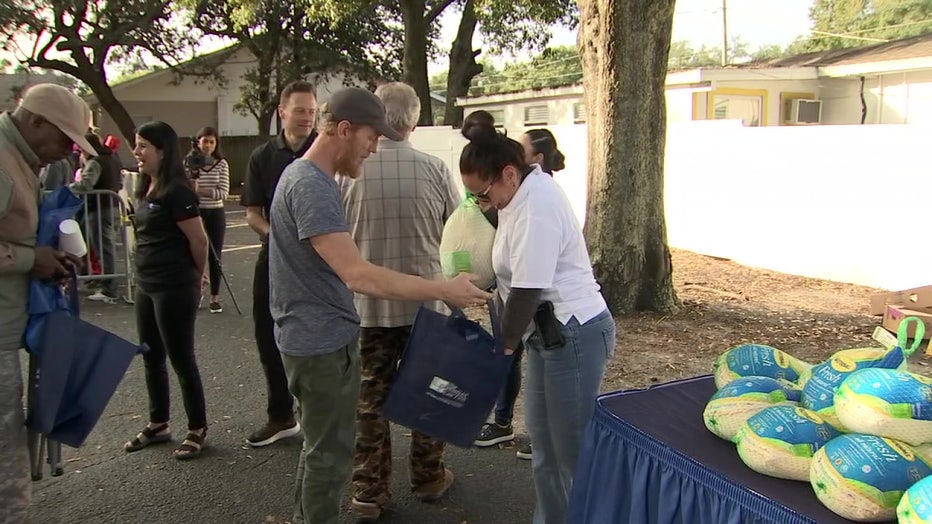 Man receives a turkey from Pendas Law Firm.