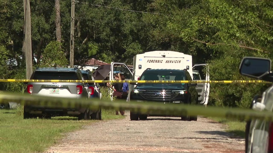 Crime scene tape and law enforcement vehicles outside homicide scene in Wimauma.