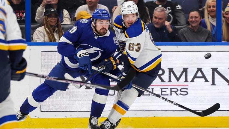 TAMPA, FL - DECEMBER 19: Nicholas Paul #20 of the Tampa Bay Lightning against Jake Neighbours #63 of the St Louis Blues during the second period at Amalie Arena on December 19, 2023 in Tampa, Florida. (Photo by Mark LoMoglio/NHLI via Getty Images)