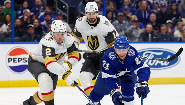 TAMPA, FL - DECEMBER 21: Brayden Point #21 of the Tampa Bay Lightning against Nicolas Hague #14 and Zach Whitecloud #2 of the Vegas Golden Knights during the third period at Amalie Arena on December 21, 2023 in Tampa, Florida. (Photo by Mark LoMoglio/NHLI via Getty Images)