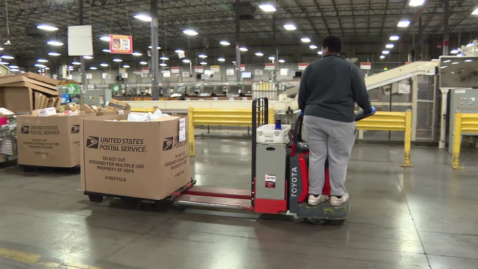 Mail handler in Ybor City moves packages throughout post office warehouse. 