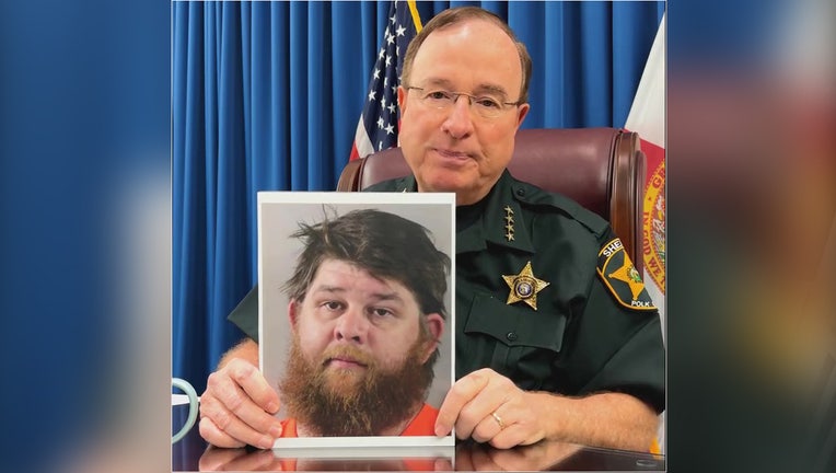 Polk County Sheriff Grady Judd holds up Eric Proctor's mugshot. Image is courtesy of the Polk County Sheriff's Office. 