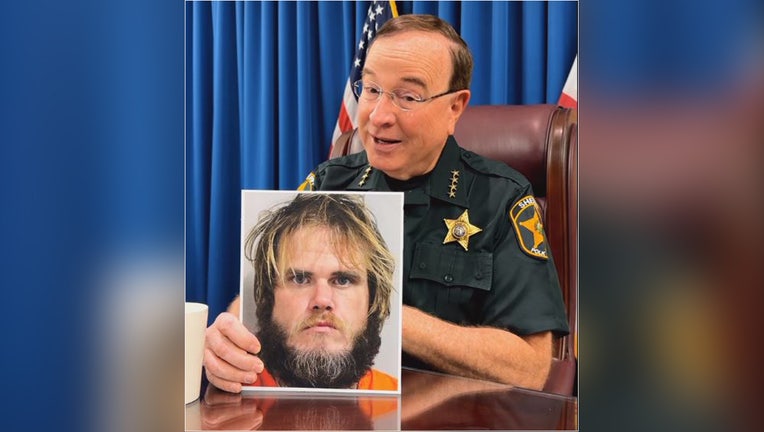 Polk County Sheriff Grady Judd with a photo of Brian Holeyfield's mugshot. 