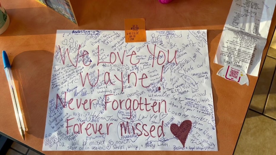 Messages from the Temple Terrace community honor A card lies next to a candle in memory of Wayne Liszewski.