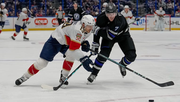 TAMPA, FL - FEBRUARY 17: Florida Panthers center Sam Reinhart (13) and Tampa Bay Lightning defenseman Haydn Fleury (7) race towards the loose puck during the NHL Hockey match between the Tampa Bay Lightning and Florida Panthers on February 17th, 2024 at Amalie Arena in Tampa, FL. (Photo by Andrew Bershaw/Icon Sportswire via Getty Images)