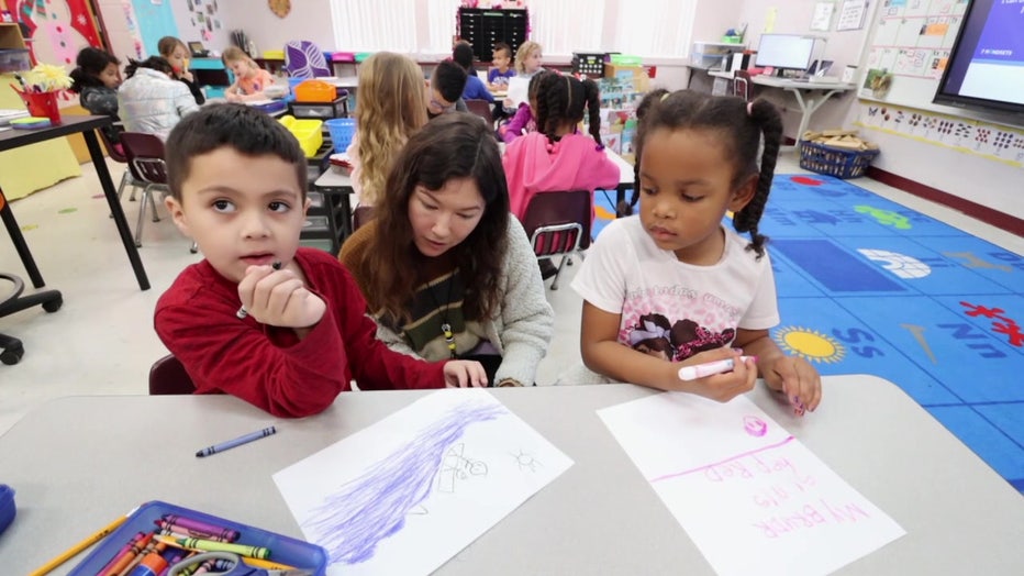 Students work with a teacher at Collins K-8 School. 