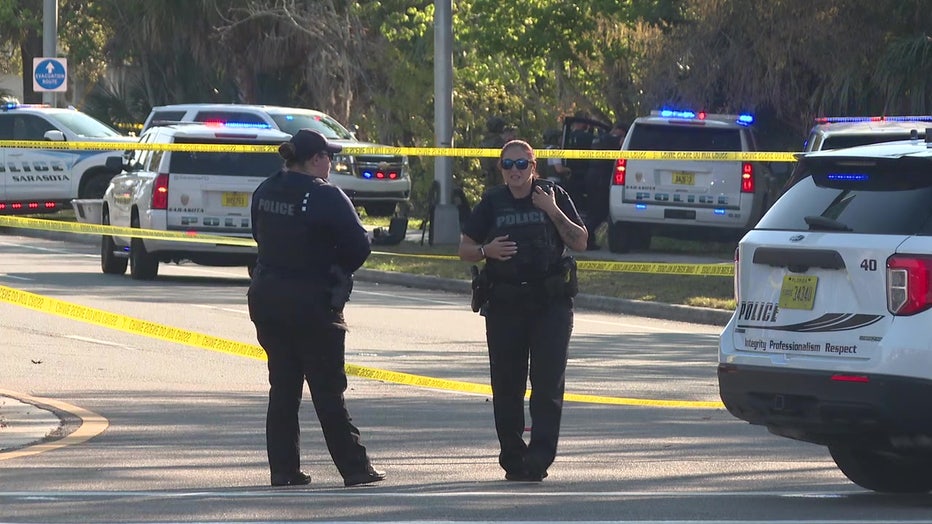 Law enforcement officers and crime scene tape at officer-involved shooting scene in Sarasota. 