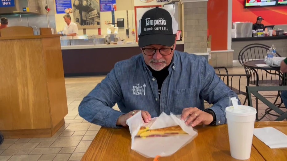 Mario Nuñez sits down to eat a Cuban sandwich. 