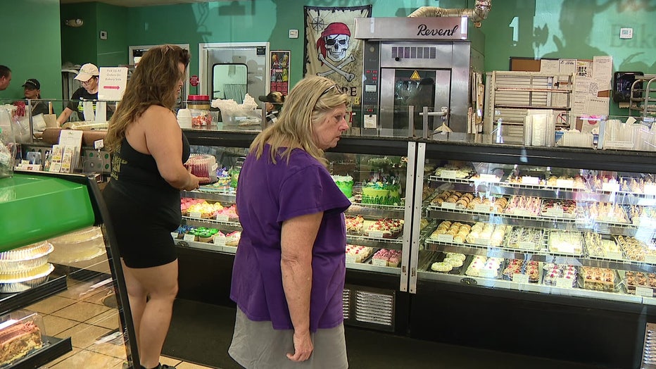 Women look at the dessert case at Alessi Bakery. 
