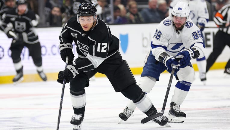 LOS ANGELES, CA - MARCH 23: Trevor Moore #12 of the Los Angeles Kings skates with the puck with pressure from Nikita Kucherov #86 of the Tampa Bay Lightning during the third period at Crypto.com Arena on March 23, 2024 in Los Angeles, California. (Photo by Kelly Smiley/NHLI via Getty Images)