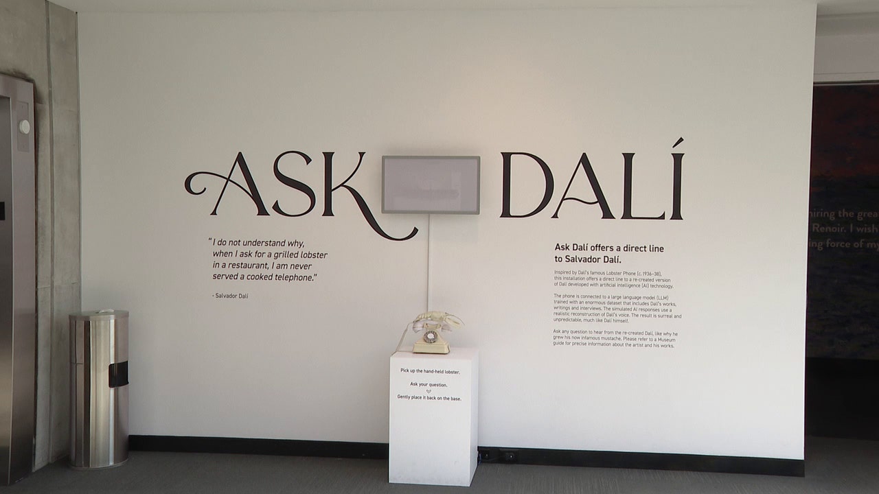 The Ask Dali exhibit. Phone is on a rectangular stand with wall behind.
