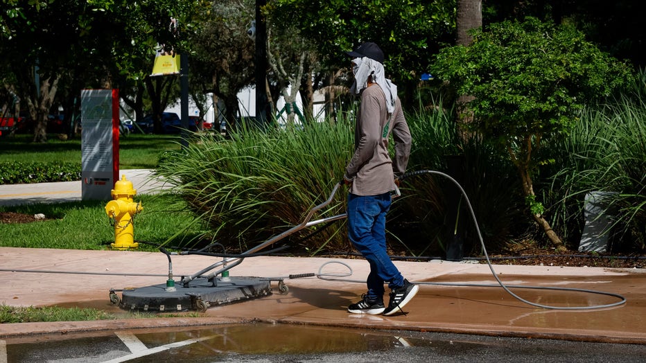A worker cleans a sidewalk during a heat wave in Miami, Florida, US, on Tuesday, July 25, 2023. Heat advisories and excessive heat warnings stretch from Californias Central Valley to Miami. Photographer: Eva Marie Uzcategui/Bloomberg via Getty Images