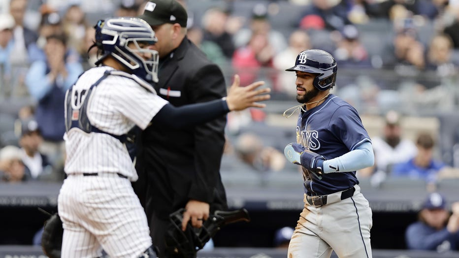 NEW YORK, NEW YORK - APRIL 21: Jose Caballero #7 of the Tampa Bay Rays trots home from third base after a balk was called during the third inning as Jose Trevino #39 of the New York Yankees reacts at Yankee Stadium on April 21, 2024 in New York City. (Photo by Jim McIsaac/Getty Images)