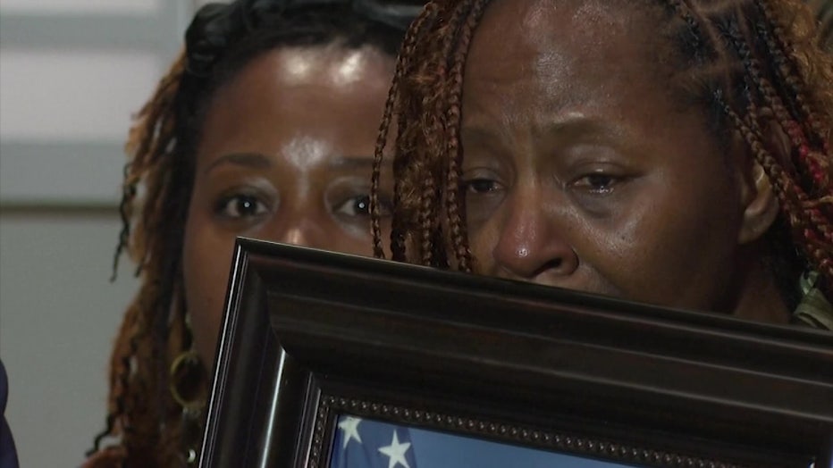 U.S. Airman Roger Fortson's mother cries as she holds a photo of her son. 