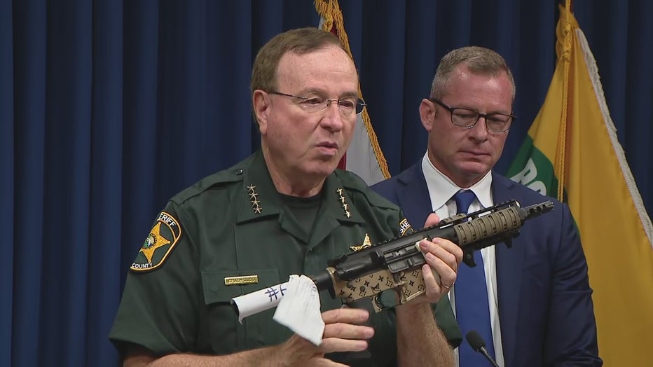 Grady Judd holds up a Louis Vuitton gun that was seized as part of the investigation. 