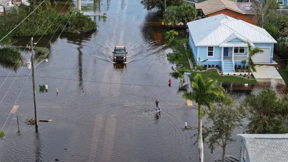 PUNTA GORDA - OCTOBER 10: In this aerial view, a person walks through flood waters that inundated a neighborhood after Hurricane Milton came ashore on October 10, 2024, in Punta Gorda, Florida. The storm made landfall as a Category 3 hurricane in the Siesta Key area of Florida, causing damage and flooding throughout Central Florida. (Photo by Joe Raedle/Getty Images / Getty Images)