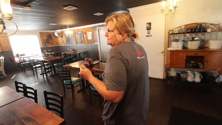 Sunny Blank, the owner of the Lazy Gator, walking through the restaurant after suffering flood damage from Hurricane Helene