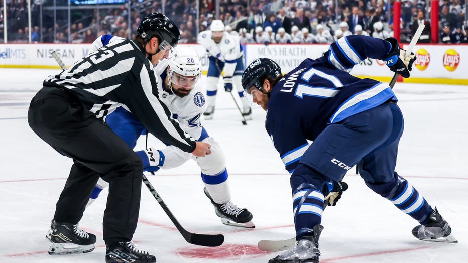 WINNIPEG, CANADA - NOVEMBER 3: Nicholas Paul #20 of the Tampa Bay Lightning and Adam Lowry #17 of the Winnipeg Jets get set to take a first period face-off at the Canada Life Centre on November 3, 2024 in Winnipeg, Manitoba, Canada. (Photo by Jonathan Kozub/NHLI via Getty Images)