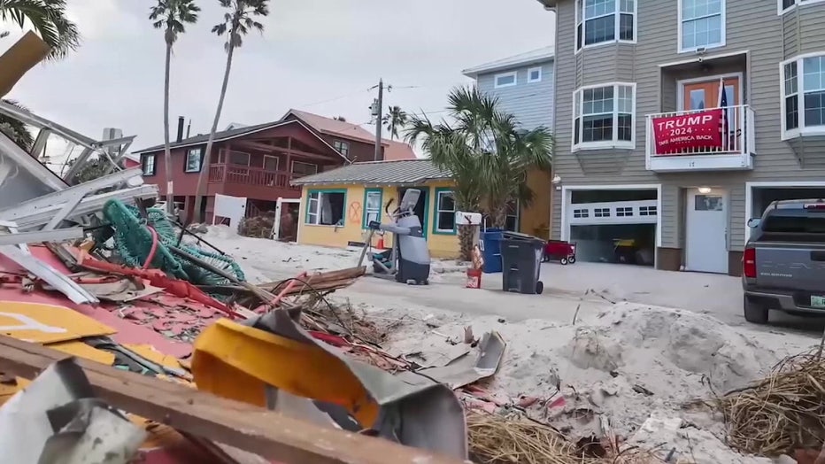 A Donald Trump for president flag surrounded by hurricane debris.