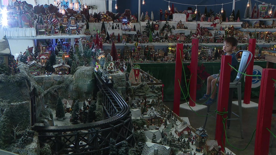 A child watches the trains move along the tracks in the Christmas Village.