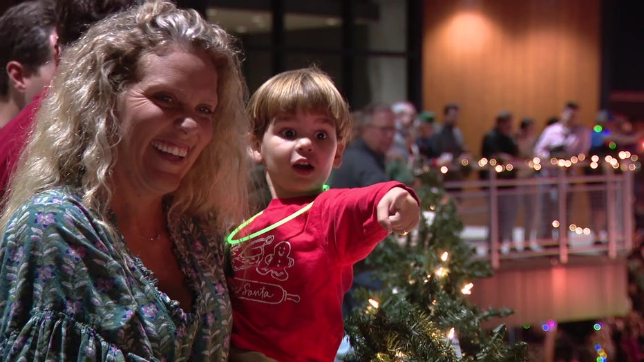 A mother and her young son smiling as they watch Lakeland's annual Christmas parade.