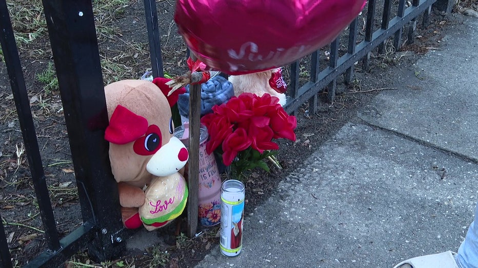 Memorial for the killed homeless man, where he was found with flowers, stuffed animals, and a balloon. 