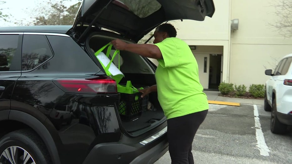Viste volunteer putting meals for elderly people in a car.