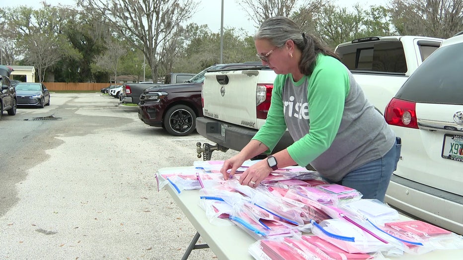 Senior Helpers volunteer over a table of Valentines Day cards for elderly people.