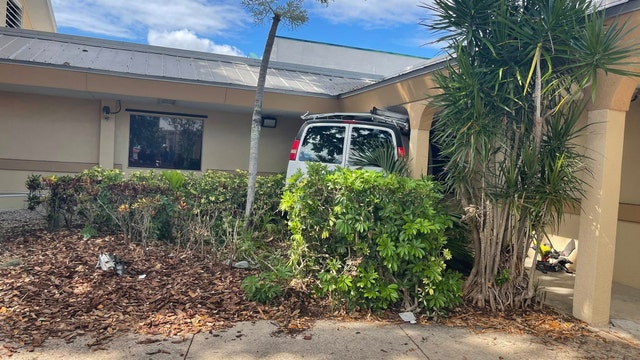 1 critically hurt after van crashes into building, fire officials say