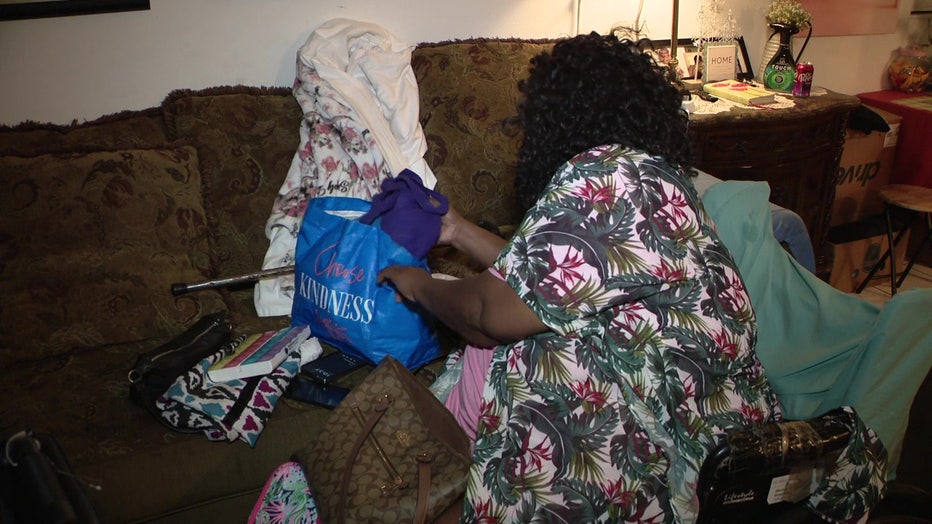 Pictured: Cora Butler gathers belongings before leaving her home after part of the roof caved in.