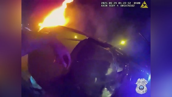 VIDEO: Officers smash through glass to rescue woman trapped in burning car