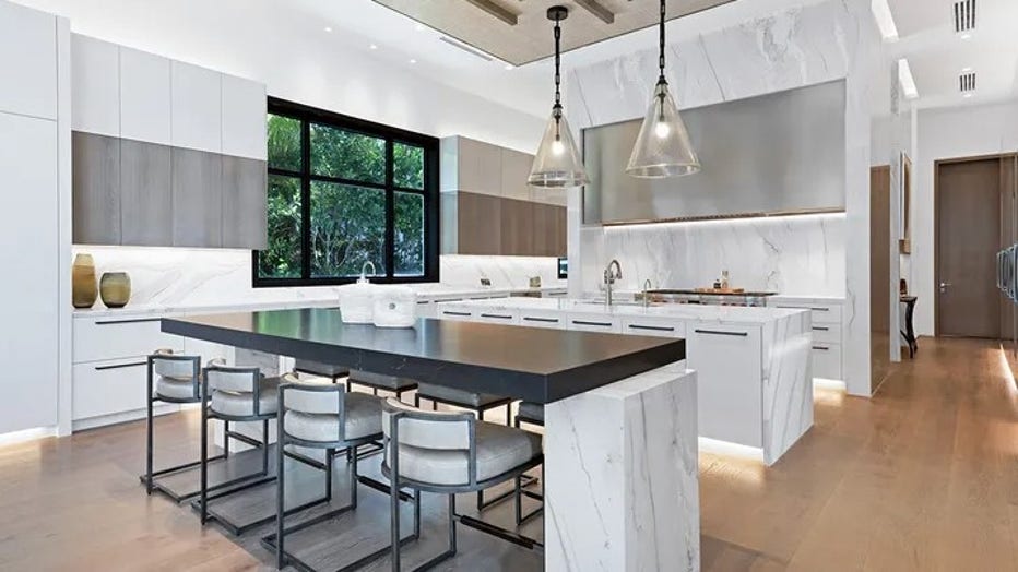 The kitchen features a center island and white cabinets. (Legendary Productions / Luxury Resort Portfolio)
