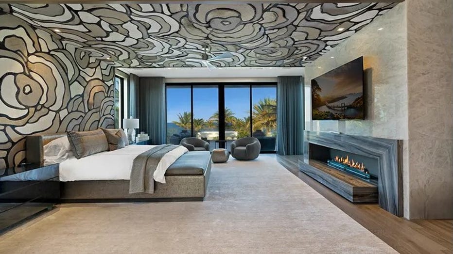 The primary bedroom features a wood-burning fireplace and views of the ocean. (Legendary Productions / Luxury Resort Portfolio)