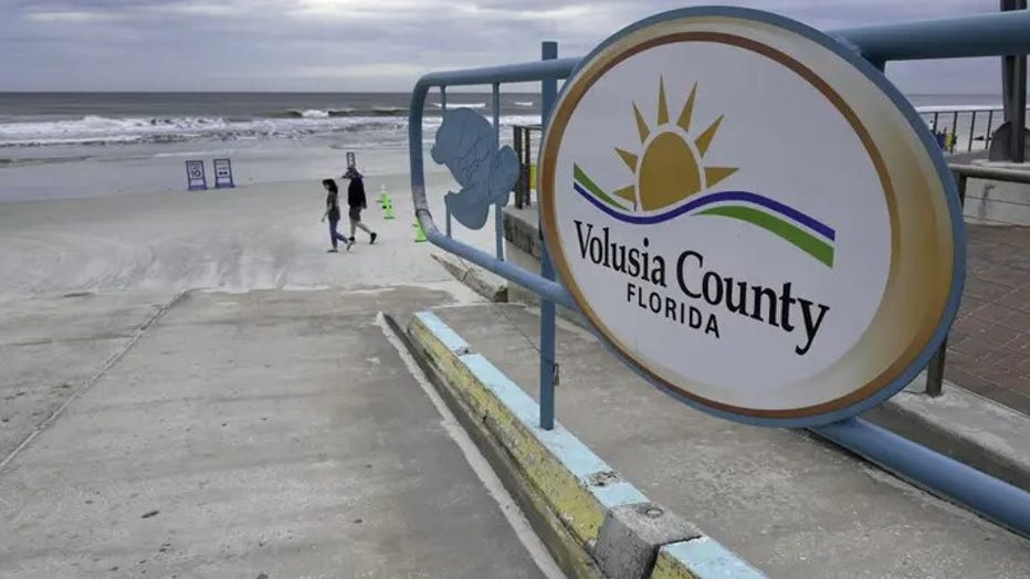 People walk past an access ramp at New Smyrna Beach in Volusia County, Florida, the area with the most shark attacks in the world, on Feb. 23, 2024. (Photo by Jesus OLARTE / AFP) (Photo by JESUS OLARTE/AFP via Getty Images)