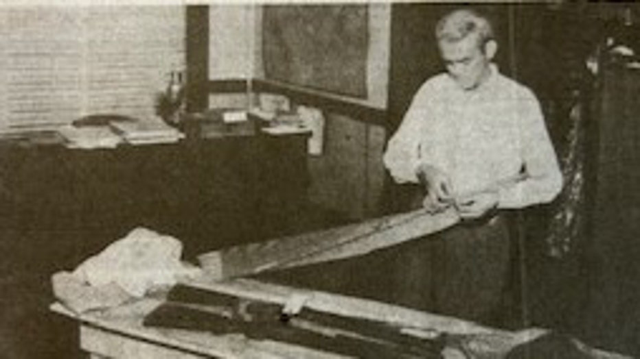Pinellas County Deputy Sheriff Bob Fulle examines evidence found in Russell's room. Note murder weapon at top of table. The shotgun underneath is Mr. Browne's.