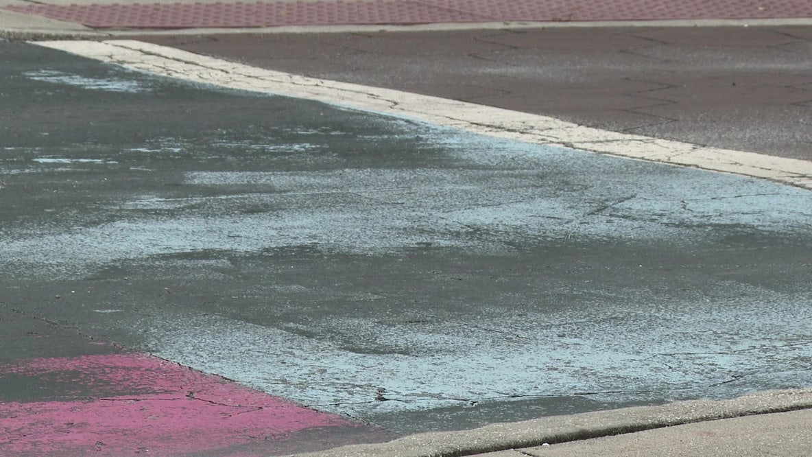 Covered St. Pete Pride mural peaks through black paint on Central Avenue