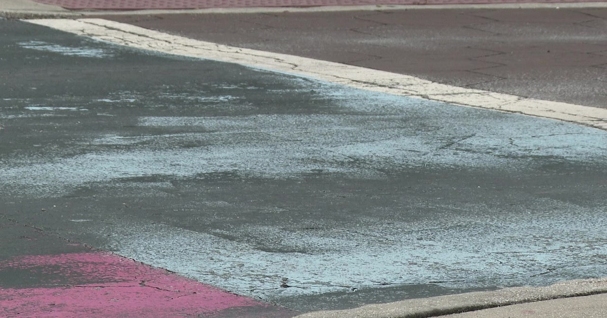 Covered St. Pete Pride mural peaks through black paint on Central Avenue
