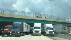 Trucks line up under turnpike overpass after man threatens to jump