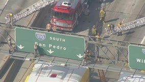 Man standing on 110 Freeway sign snarls traffic in Downtown Los Angeles