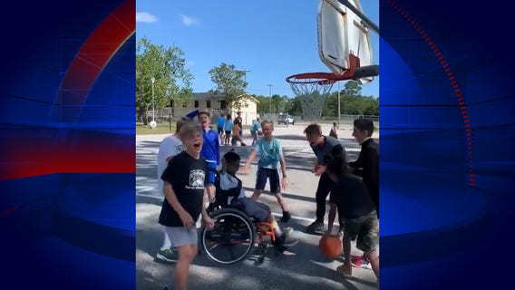 Kids play basketball with wheelchair-bound student