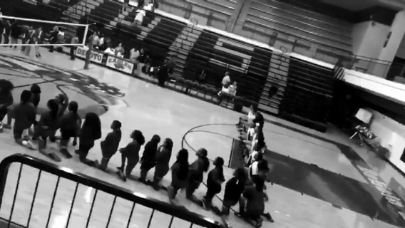 DeSoto High School volleyball team kneels during national anthem