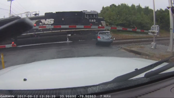 VIDEO: Woman runs out of car just before train hits it