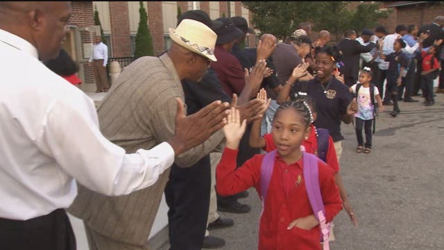 Black men gather to cheer on students returning to school in Detroit