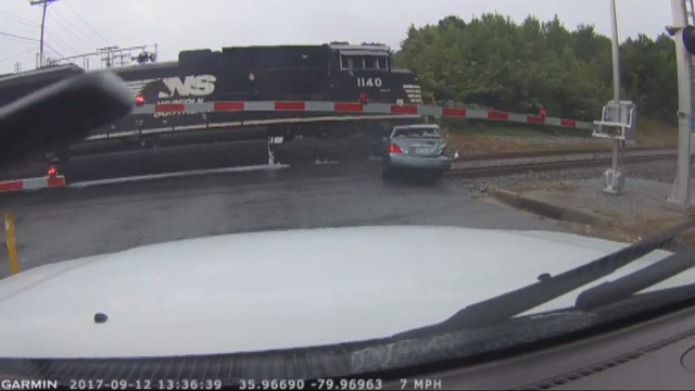 VIDEO: Woman runs out of car just before train hits it